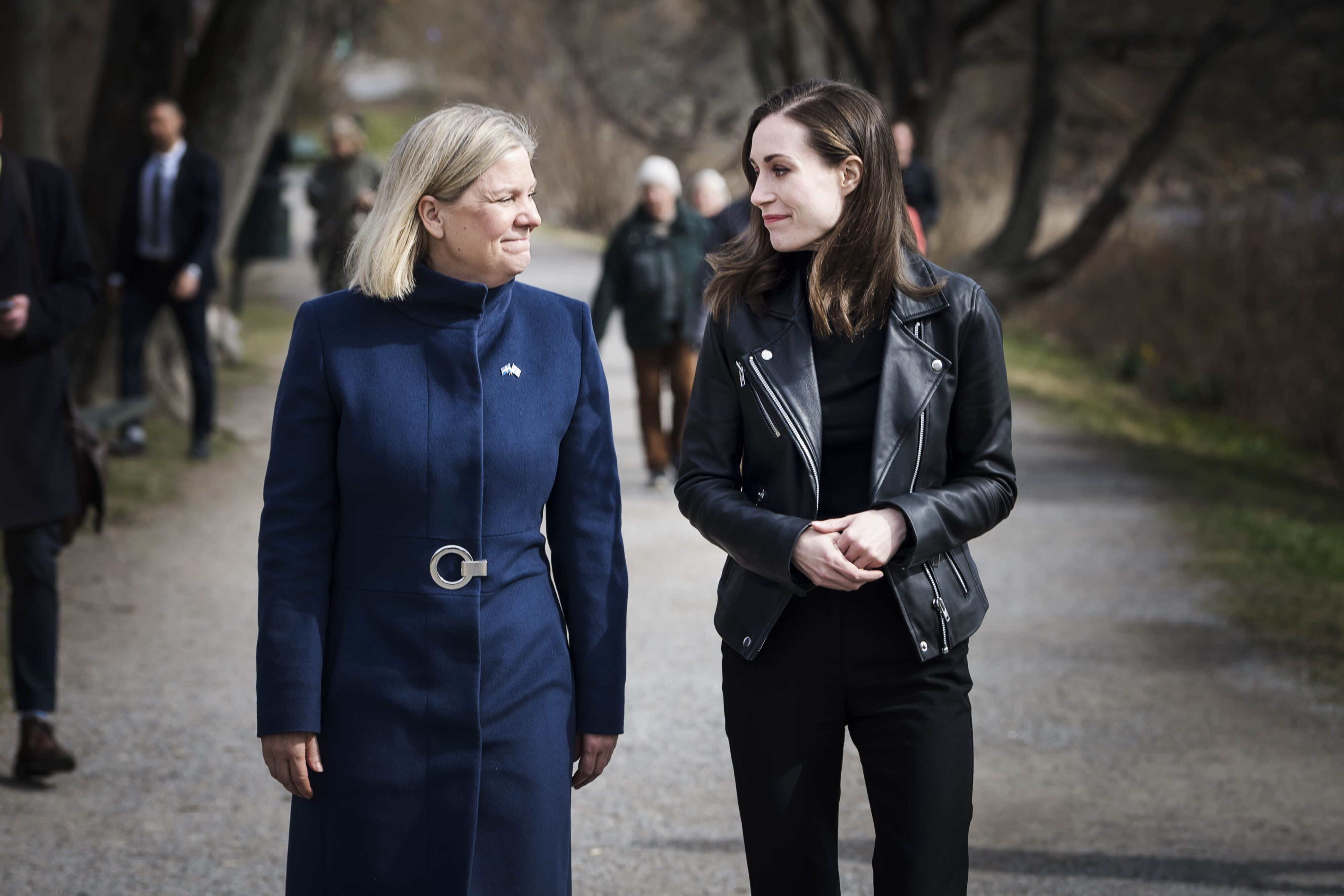 Magdalena Andersson klädd i blått och Sanna Marin klädd i svart promenerar.